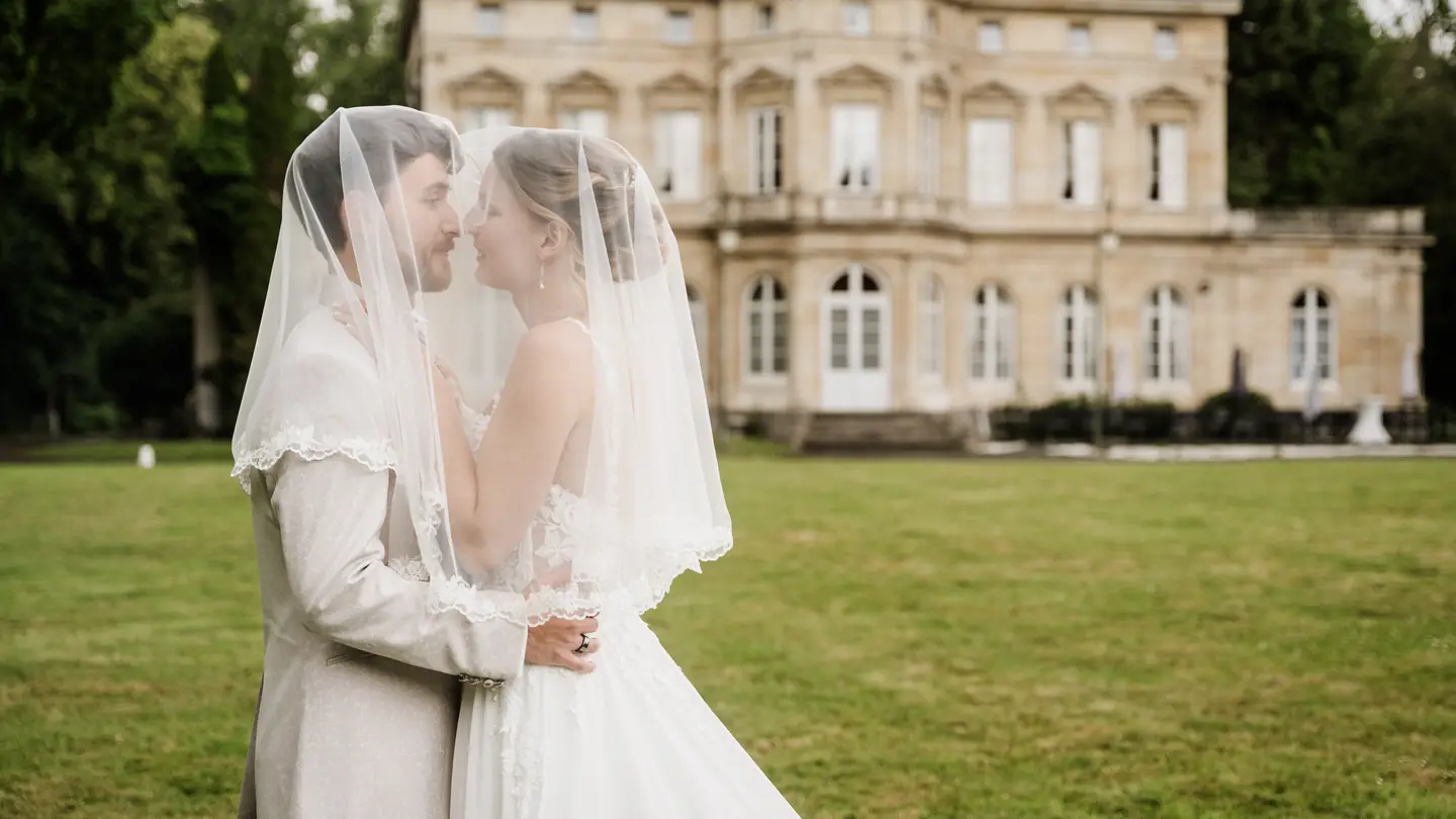 Alice et Léo sous le voile, sur la pelouse d'un château