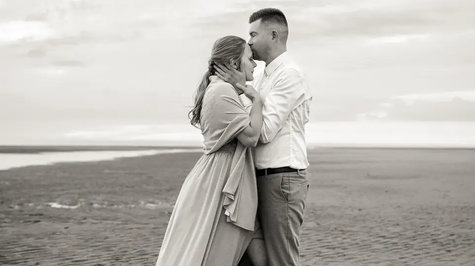 Blandine et Cédric enlacés sur le sable, en noir et blanc