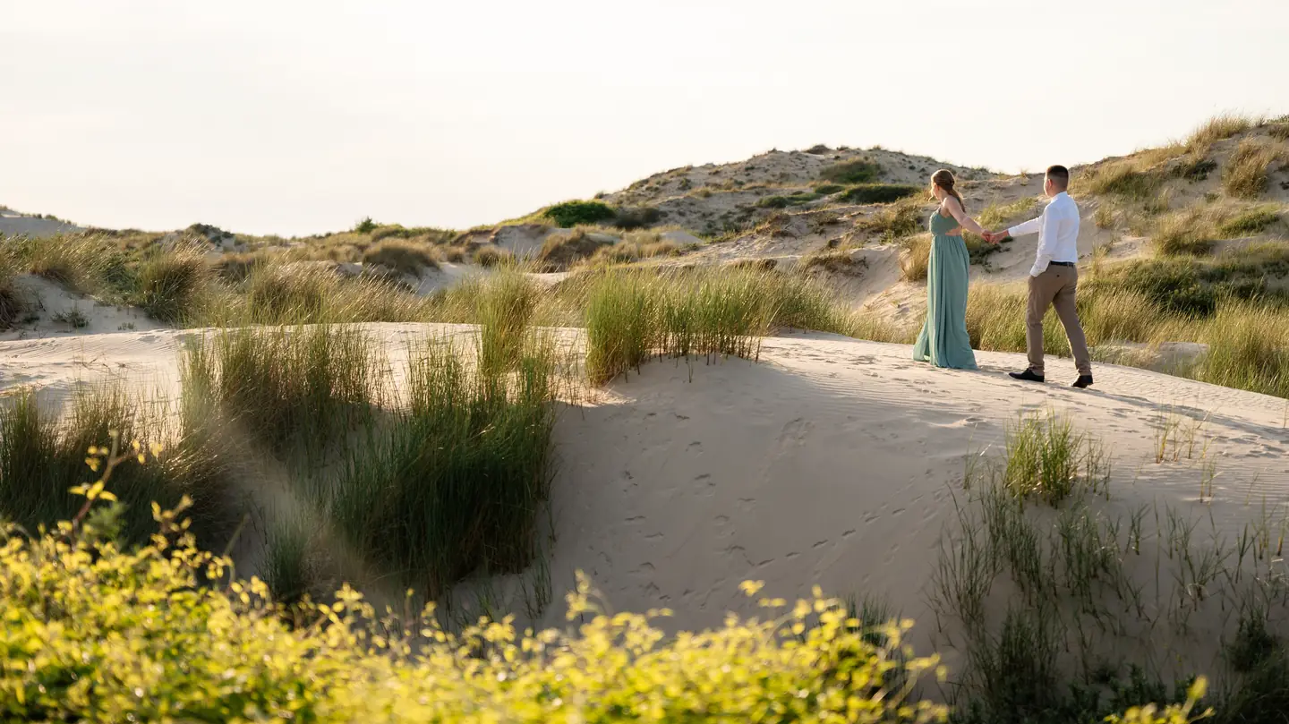 Blandine et Cédric marchent au loin dans les dunes
