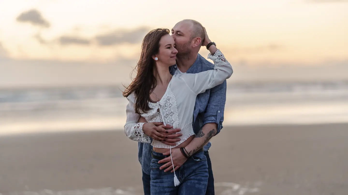 Cyndel et François enlacés face à la mer au coucher du soleil